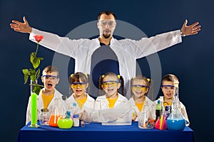 Happy kids with scientist doing science experiments in the laboratory