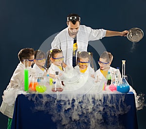 Happy kids with scientist doing science experiments in the laboratory