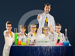 Happy kids with scientist doing science experiments in the laboratory