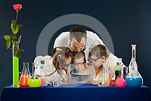 Happy kids with scientist doing science experiments in the laboratory photo