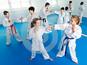 Happy kids sparring in pairs in karate class