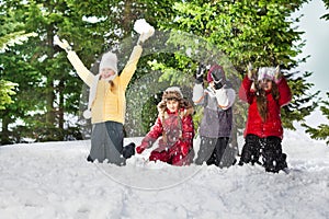 Happy kids standing on knees at sunny winter day