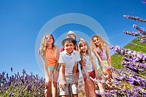 Happy kids standing together in lavender field