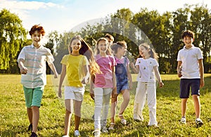 Happy kids standing together walking outdoors and smiling in the summer park. photo