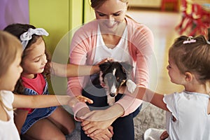 Happy kids stroking cute dog