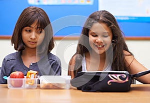 Happy kids, students and eating food in classroom at school for meal, break or snack time. Young little girls or