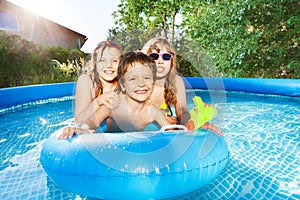 Happy kids swimming in the pool with rubber ring photo