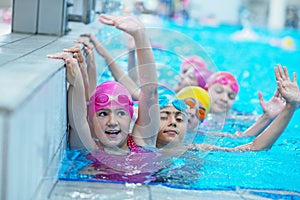 Happy kids at the swimming pool. young and successful swimmers pose.