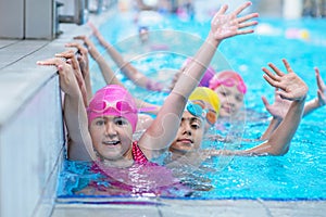 Happy kids at the swimming pool. young and successful swimmers pose.