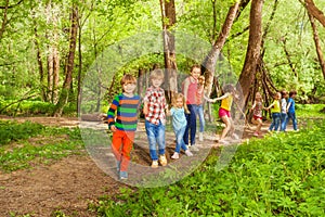 Happy kids walking together holding hands in park