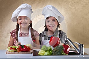 Happy kids washing vegetables for a salad