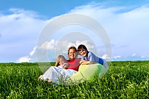 Happy kids and woman sitting outdoors