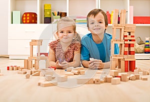 Happy kids with wooden blocks on the floor