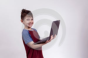 Happy kindergarten child holding a laptop