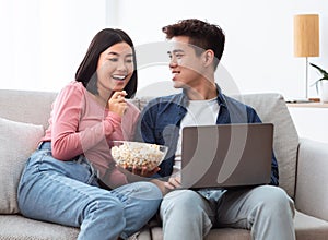 Happy Korean Couple Watching Movie On Laptop Online At Home