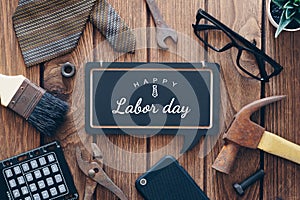 Happy Labor day background concept. Flat lay of construction blue collar handy tools and white collar`s accessories over wooden