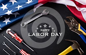 Happy Labor day concept. American flag with different construction tools on black table background, with copy space for text