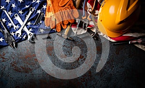 Happy Labor day concept. American flag with different construction tools on dark stone background, with copy space for text