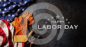 Happy Labor day concept. American flag with different construction tools on dark stone background, with copy space for text