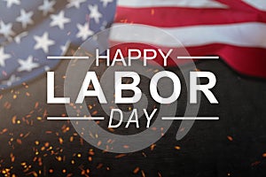 Happy Labor day concept. American flag with different construction tools on dark stone background, with copy space for text.