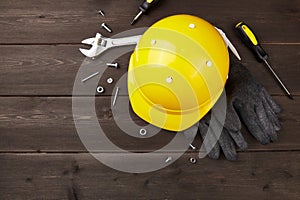 Happy labor day concept. Construction tools, yellow helmet on dark wooden background