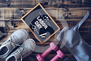 Happy Labor Day Fitness and healthy active lifestyle background concept. Training sneakers, dumbbells, sport bra and headphones on