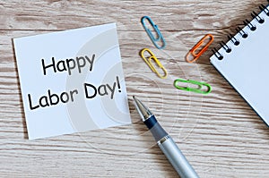 Happy labor Day - message on wooden table background with office supplies. Labour day celebrated at May 1. Spring time