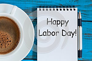 Happy Labor day - note at table with morning coffee cup, 1st of May background. With copy space for text, mockup or