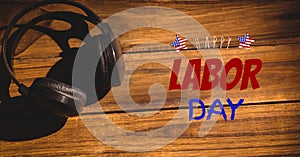 Happy labor day text against headphone on wooden background