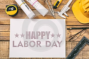 Happy Labor Day text and construction tools on wood. USA holiday celebration