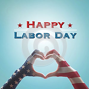 Happy labor day text message with America flag pattern on people hands in heart shaped on vintage blue sky background