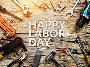 Happy Labor day text in white color on wooden background with construction repair tools.