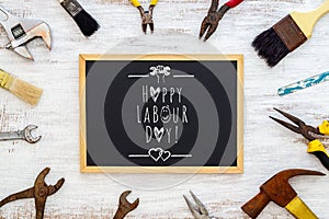 Happy Labour Day background concept. Rusty old hand tools with blackboard and text writing Happy Labour day photo