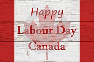 Happy Labour Day Canada message with Canadian maple leaf flag on wood