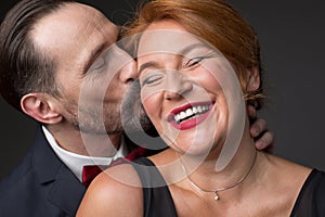 Happy lady enjoying kiss of her husband