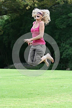 Happy lady in fifties jumping for joy