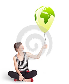 Happy lady holding a green globe balloon