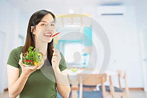 Happy lady holding kichen stuff over copy space background