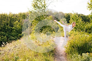 Happy lady practicing yoga, standing in Warrior three exercise, Virabhadrasana III pose