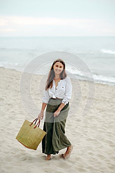 Happy lady smiling at camera while strolling along seaside