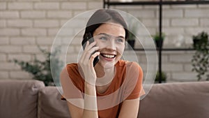 Happy lady speaking by phone holding device close to ear