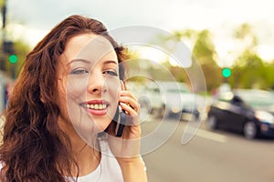 Happy lady talking on mobile phone walking on a street