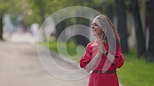 happy lady is walking in park and chatting with met buddy, smiling and waving hand