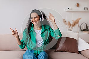 Happy Lady Wearing Earphones Listening To Music Having Fun Indoor