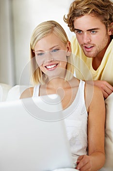 Happy, laptop and young couple on sofa browsing on social media or the internet at apartment. Smile, technology and man