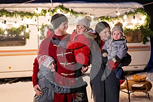 Happy large family celebrates christmas in nature and holds sparklers. Parents with three sons travels in a mobile home.