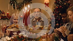 Happy large family praying on Christmas dinner