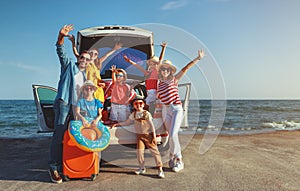 Happy large family  in summer auto journey travel by car on beach