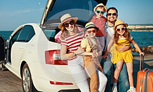 Happy large family  in summer auto journey travel by car on beach