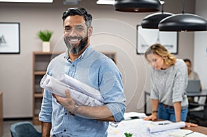 Happy latin architect holding blueprints